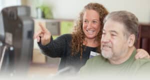 A Wolf Creek rehab therapist with a resident in the rehab gym
